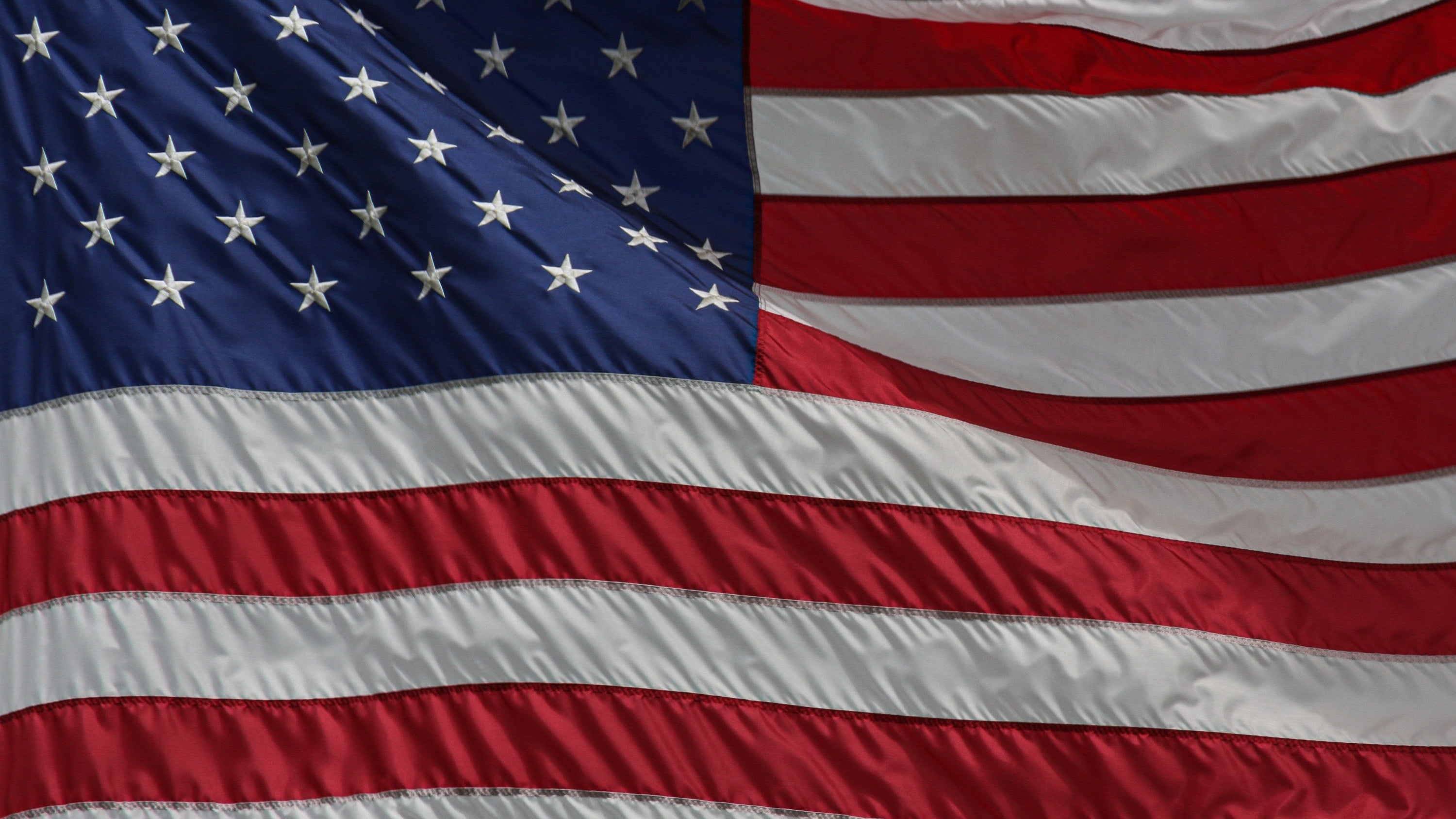 Close-up of the American flag with detailed fabric texture.